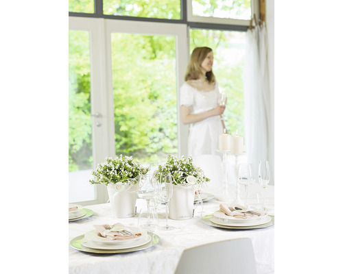 Festlich gedeckter Tisch mit Blumenarrangements und Kerzen für einen besonderen Anlass.