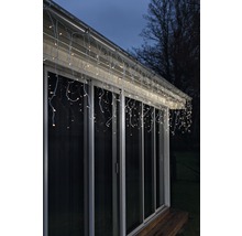 Guirlande lumineuse en forme de glaçons illuminée sur le toit d''une maison