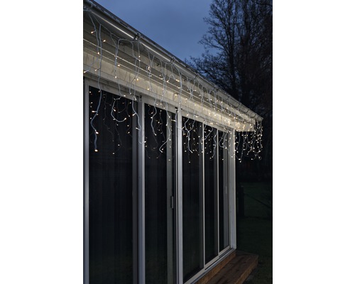 Guirlande lumineuse en forme de glaçons illuminée sur le toit d''une maison