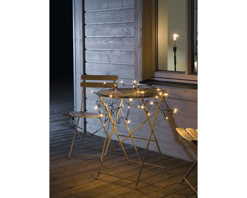 Guirlande lumineuse filet LED Konstsmide 3 m + longueur de câble 10 m 96 LED couleur d'éclairage ambre Scène de jardin avec guirlande lumineuse sur table et chaises sur une terrasse