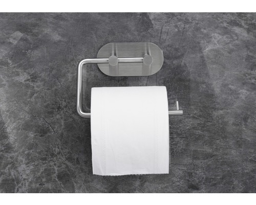 Toilettenpapierhalter mit Toilettenpapierrolle an grauer Wand