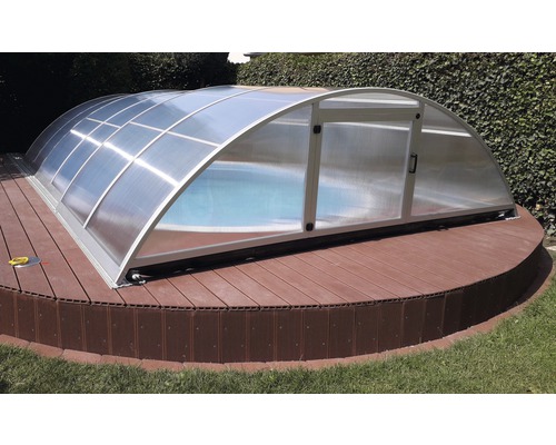 Abri de piscine sur terrasse en bois dans le jardin