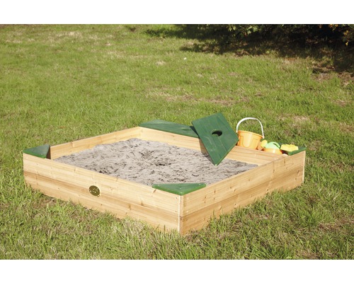 Bac à sable carré en bois avec couvercle et jouets sur une pelouse.