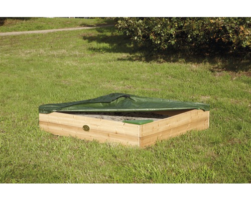 Bac à sable carré en bois avec une couverture verte sur une pelouse