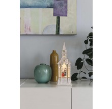 Dekorative beleuchtete Kirche mit Krippe und zwei Vasen als festliche Dekoration