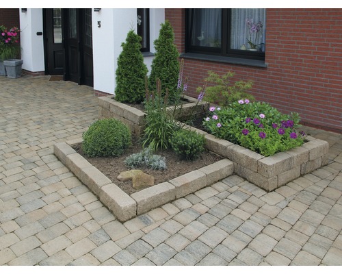 Aussenbereich mit Pflastersteinen und bepflanzten Steintrögen