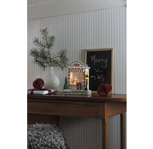 Dekoratives Weihnachtsstilleben mit beleuchteter Schneekugel auf einem Holztisch