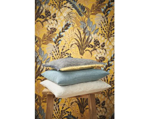 Coussins décoratifs sur un tabouret devant un papier peint à motifs