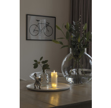 Scène de table décorative avec bougie, vases et image de vélo