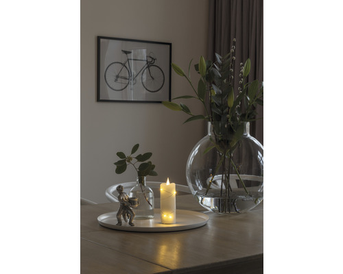 Scène de table décorative avec bougie, vases et image de vélo