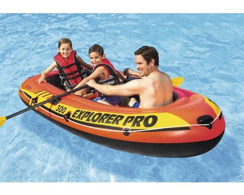 Bateau pneumatique gonflable avec pagaie et personnes dans l''eau