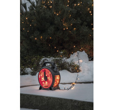 Lichterkette auf Kabeltrommel vor schneebedecktem Busch