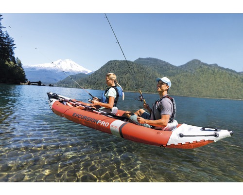 Des personnes pêchent dans un kayak gonflable sur un lac.