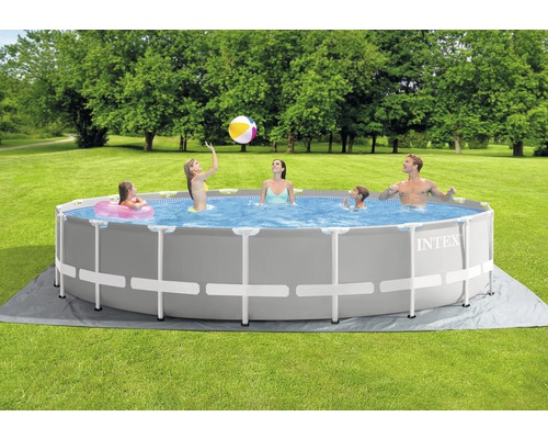 Une famille se baigne dans une piscine hors-sol Intex dans le jardin.
