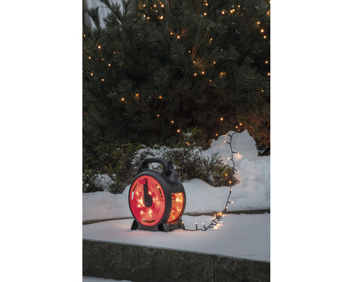 Guirlande lumineuse avec enrouleur devant un buisson enneigé
