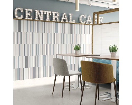 Heller Raum mit Wandfliesen, Tischen und Stühlen im Café-Stil.