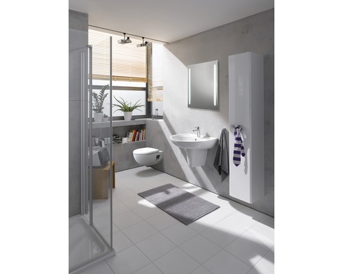 Salle de bains lumineuse avec lavabo, miroir, toilettes et armoire de salle de bains