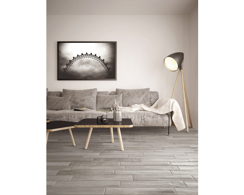 Salon avec canapé, table, lampadaire et carrelage de sol aspect bois