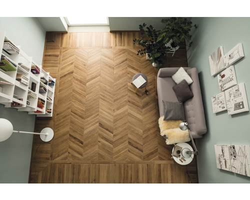 Vue plongeante d''une pièce avec un plancher en bois à chevrons, une bibliothèque, un canapé, une table d''appoint et des décorations murales