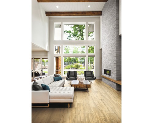 Salon lumineux avec canapé, fauteuils, cheminée et grande fenêtre