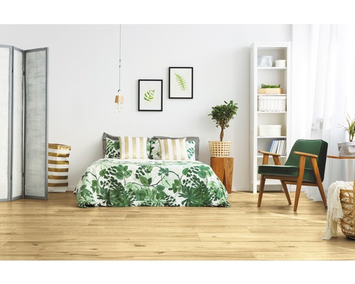 Chambre claire avec plancher en bois, lit, fauteuil et décoration