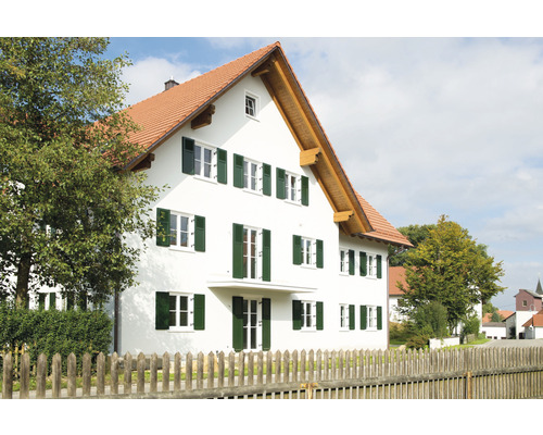 Une maison d''habitation à deux étages avec des volets en bois et un toit à deux pans