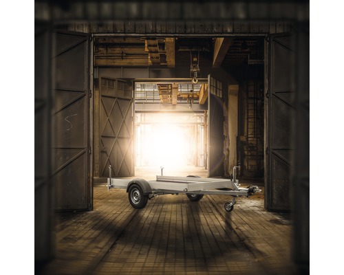 Anhänger in einer Industriehalle mit geöffneten Toren.