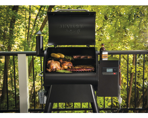 Traeger Grill mit Speisen wie Hähnchen, Maiskolben und Rippchen auf dem Grillrost