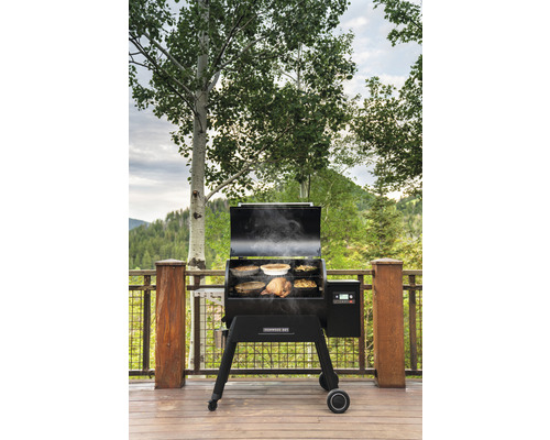 Holzpelletgrill auf einer Terrasse mit Speisen im Inneren