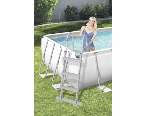 Scène avec piscine à cadre en acier et une femme entrant dans l''eau par une échelle de piscine