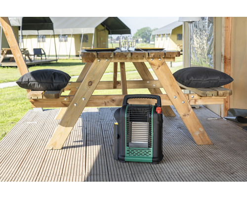 Scène de camping avec table de pique-nique, coussins et chauffage portable