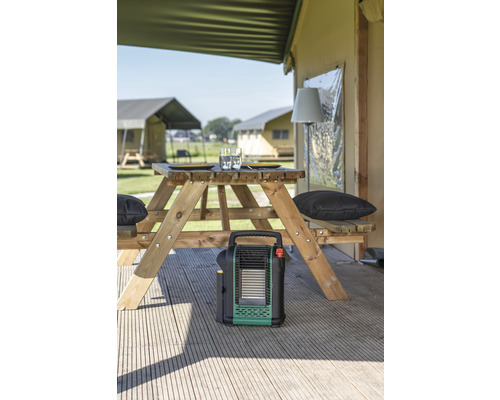 Scène avec table de pique-nique, appareil de chauffage et tentes en arrière-plan