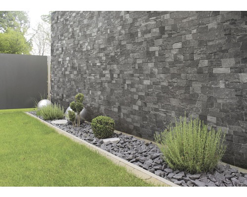 Garten mit Steinwandverkleidung, Zierkies und Pflanzen