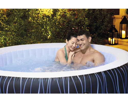 Un couple se détend dans un jacuzzi gonflable dans le jardin.