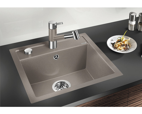 Évier avec robinet et restes de nourriture dans une assiette