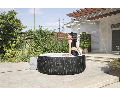 Bain à remous Lay-Z-Spa gonflable avec femme dans le jardin.
