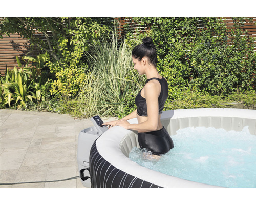 Femme utilisant un jacuzzi gonflable dans le jardin