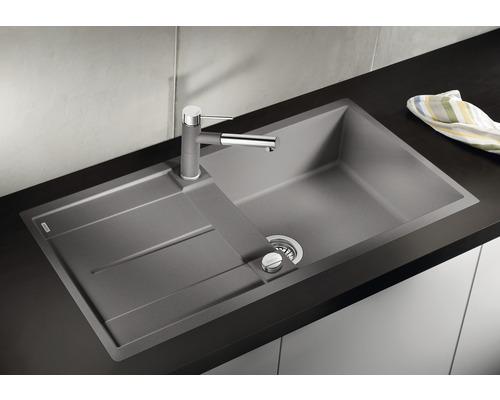 Spüle aus Stein mit Abtropffläche und Wasserhahn