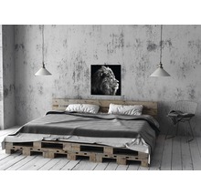 Chambre avec lit en palettes, lampe et photo de lion