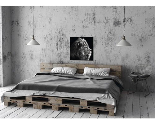 Chambre avec lit en palettes, lampe et photo de lion