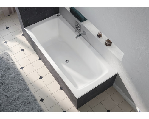 Baignoire intégrée dans une salle de bain avec robinetterie et étagère