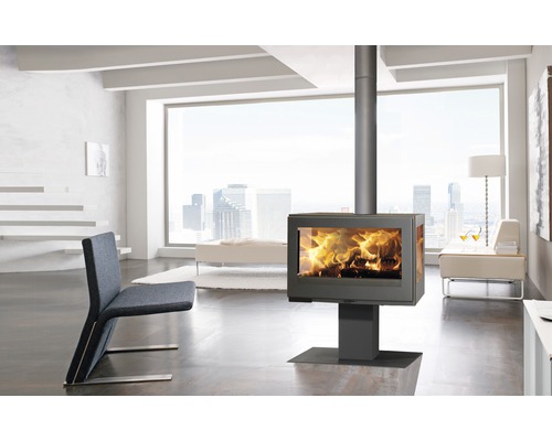 Poêle à bois dans un salon moderne avec fauteuil et grande baie vitrée