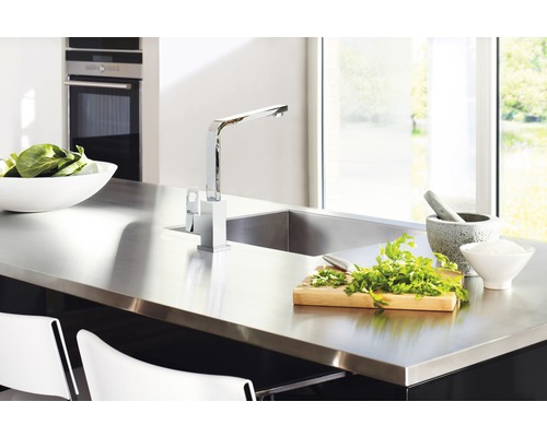 Cuisine moderne avec évier en acier inoxydable, robinet, herbes et saladier