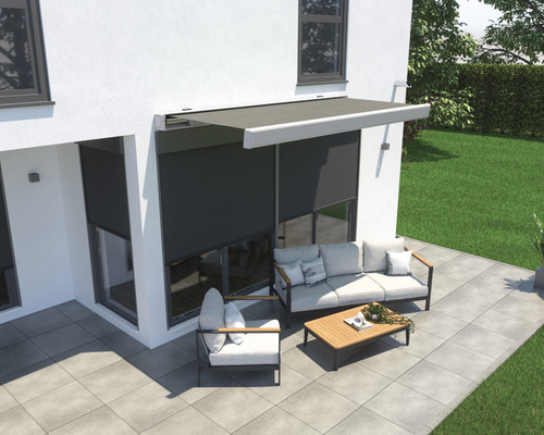 Terrasse avec store, coin salon et pavés devant une maison