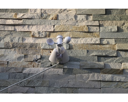 Station météo avec anémomètre sur mur de pierre