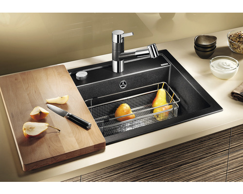 Évier de cuisine avec robinet, planche à découper, couteau et fruits