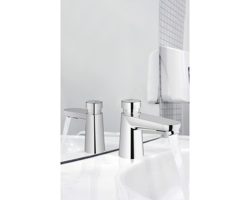 Deux robinets de lavabo avec jet d''eau sur un lavabo blanc