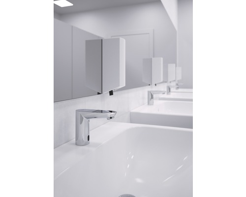 Reihe von Waschbecken mit berührungslosen Armaturen und Papierhandtuchspendern in einem Badezimmer