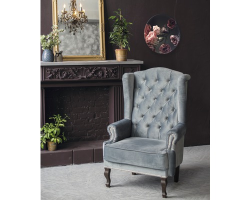 Vue intérieure avec fauteuil à oreilles, cheminée et décoration