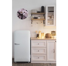 Küchenszene mit Kühlschrank, Wandregal und runder Dekoration mit Blumenmuster